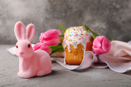 Cute Easter bunny with cake and flowers on grunge backgroundの写真素材