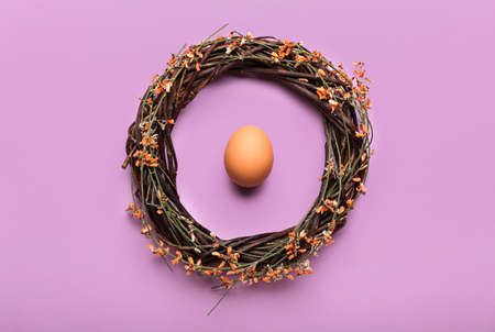 Beautiful Easter wreath and egg on lilac backgroundの写真素材