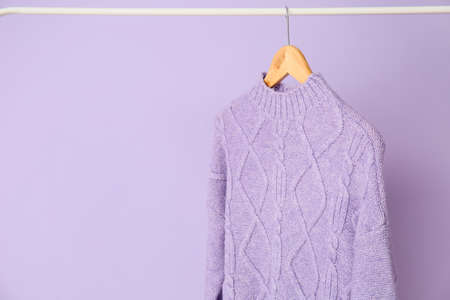 Rack with lilac sweater on color backgroundの写真素材