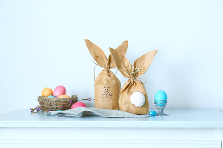 Paper bags bunny with Easter eggs on table in room