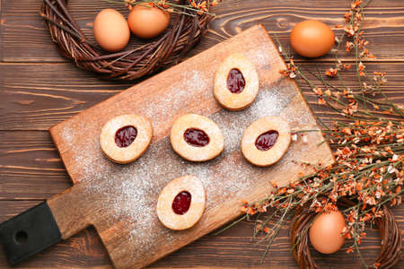 Beautiful Easter composition with tasty cookies, eggs and flowers on wooden backgroundの写真素材