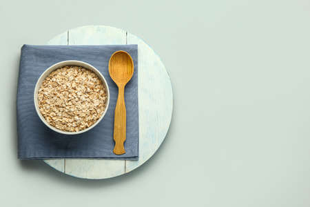 Bowl with raw oatmeal flakes on gray backgroundの写真素材