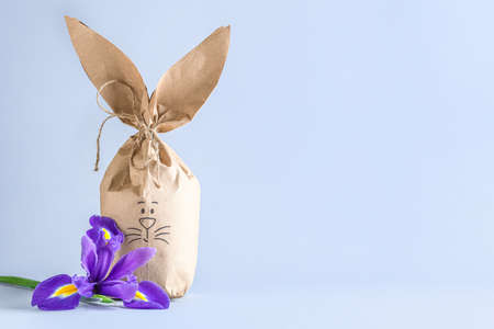 Paper bag bunny and iris flower on gray background