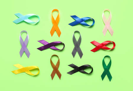 Different awareness ribbons on green background. world cancer day concept