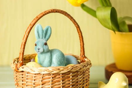 Wicker basket with Easter bunny and eggs, closeup