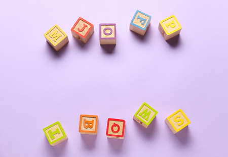 Wooden cubes with letters on color background
