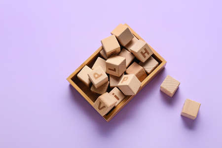 Box with wooden cubes on color backgroundの写真素材