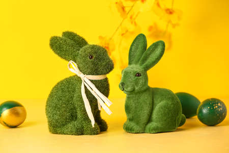Green Easter bunnies and eggs on yellow backgroundの写真素材
