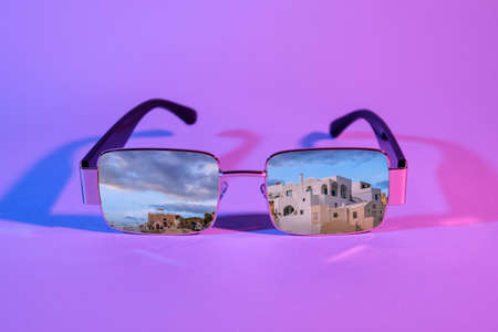 Stylish sunglasses with reflection of old city on purple backgroundの写真素材
