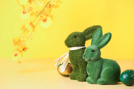 Green Easter bunnies and eggs on yellow background