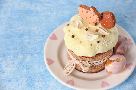 Plate with tasty Easter cake decorated with cookies and eggs on color background