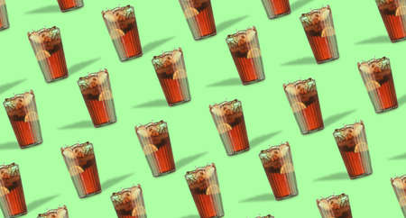 Glasses of tasty Cuba Libre cocktail on green background. pattern for design