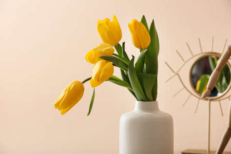 Vase with bouquet of tulips on color backgroundの写真素材