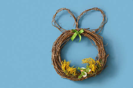 Easter wreath with mimosa flowers on blue wallの写真素材