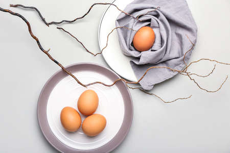 Composition with plates of Easter eggs on light backgroundの写真素材