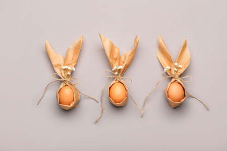 Packed Easter eggs and flowers on light background
