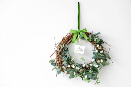 Beautiful Easter wreath with greeting card on white backgroundの写真素材