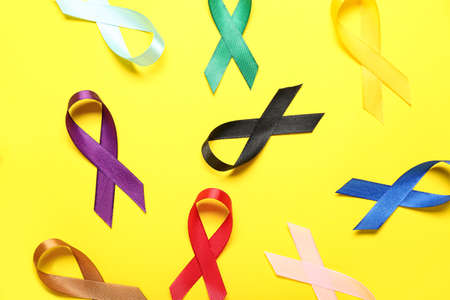Colorful awareness ribbons on yellow background, closeup. World Cancer Dayの写真素材