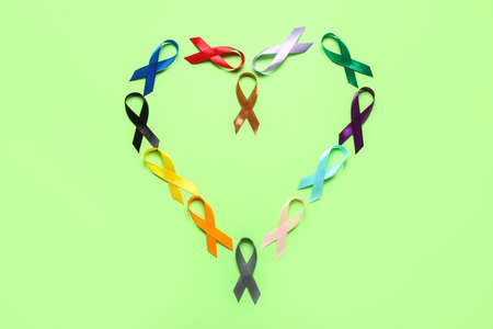 Heart frame made of awareness ribbons on green background. world cancer day conceptの写真素材