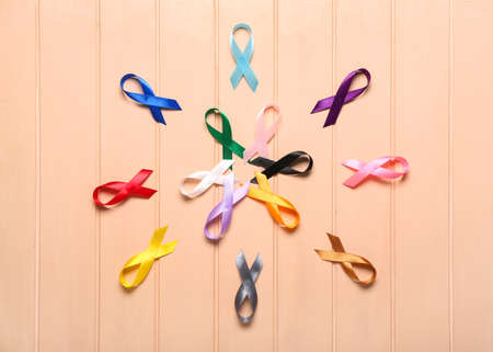 Different awareness ribbons on color wooden background. world cancer day concept