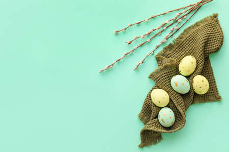 Painted Easter eggs and willow branches on blue background