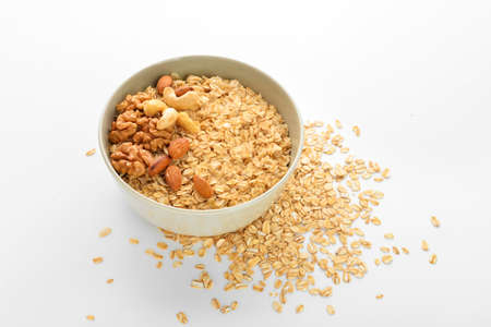 Bowl of healthy oatmeal with nuts on white backgroundの写真素材