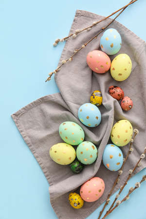 Painted Easter eggs and willow branches on blue background