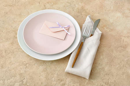 Simple table setting and envelope on beige grunge backgroundの写真素材