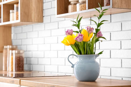 Bouquet of tulips on kitchen counter near white brick wallの写真素材