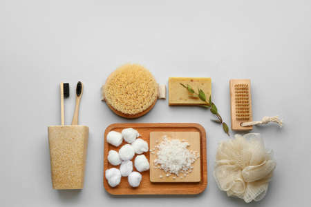 Set of bath supplies with massage brushes on light background