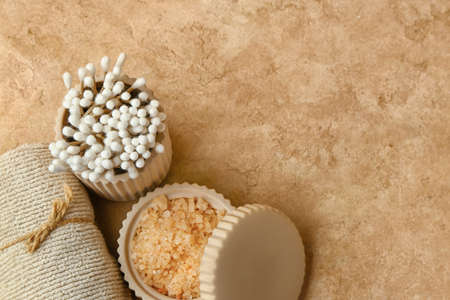Bowl of sea salt, cotton swabs and clean towel on color background, closeupの写真素材