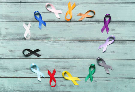Frame made of different awareness ribbons on color wooden background. World Cancer Dayの写真素材