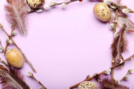 Stylish wreath with Easter eggs, willow branches and feathers on purple backgroundの写真素材