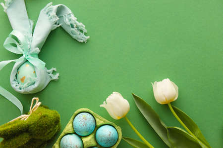 Composition with Easter eggs, bunny and tulip flowers on green backgroundの写真素材