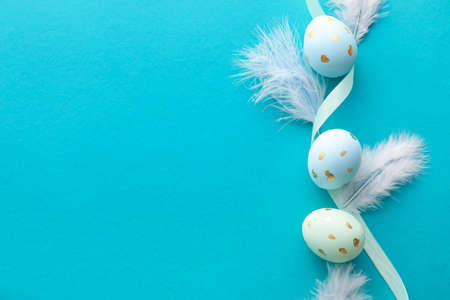 Composition with Easter eggs, feathers and ribbon on color background, closeupの写真素材