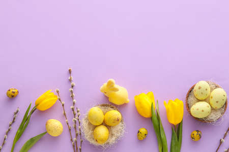 Composition with Easter eggs, bunny and tulip flowers on lilac background