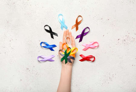 Female hand with awareness ribbons on light background. World Cancer Dayの写真素材