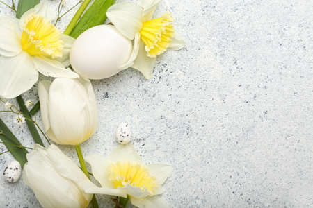 Composition with beautiful flowers and Easter eggs on light background, closeup