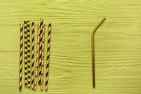 Stylish straws for drinks on green wooden background. concept of uniquenessの写真素材