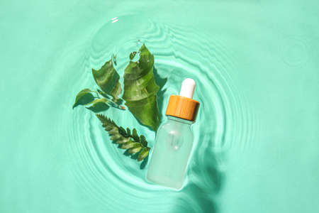 Bottle of healthy serum and plant leaves in water on color background