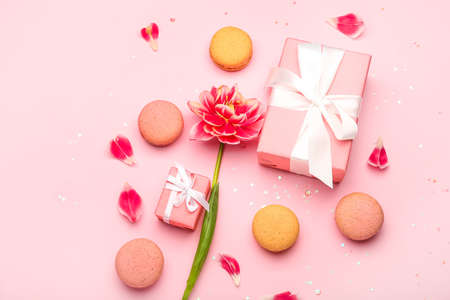 Composition with gifts for International Women's Day celebration, macaroons and tulip flower on pink backgroundの写真素材