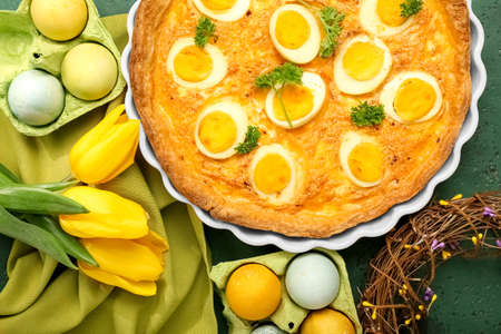 Composition with tasty Easter tart, painted eggs and tulip flowers on color background, closeupの写真素材