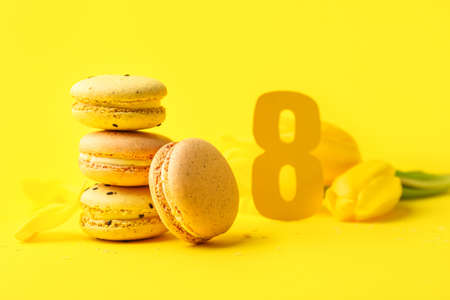 Stack of sweet macaroons on yellow background. International Women's Day celebrationの写真素材
