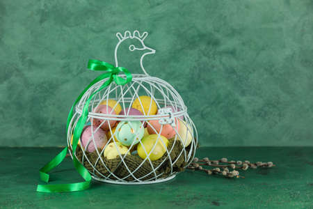 Basket of painted Easter eggs on green backgroundの写真素材