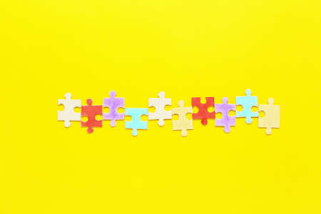 Puzzle pieces on yellow background. Concept of autistic disorder