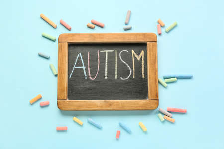 Chalk board with word AUTISM on blue background