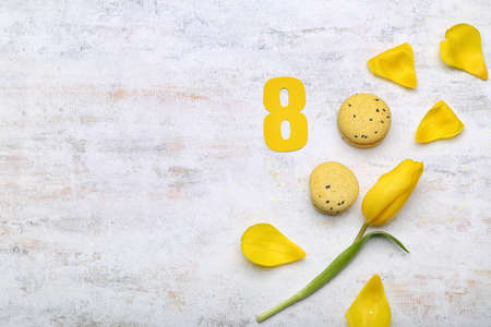 Paper figure 8, yellow tulip flower and macaroons on light background