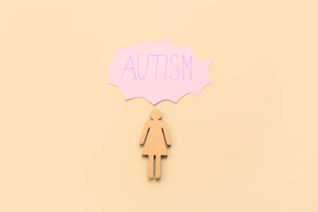 Wooden female figure with word AUTISM on gray backgroundの写真素材