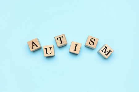 Wooden cubes with word AUTISM on blue backgroundの写真素材