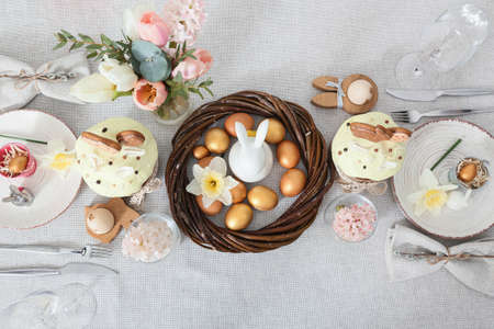 Beautiful Easter setting with flowers on light tablecloth